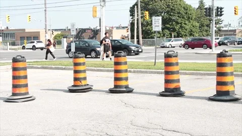 Five traffic delineators drums barrels pylons cylinders in parking lot with road Video stock 252042672