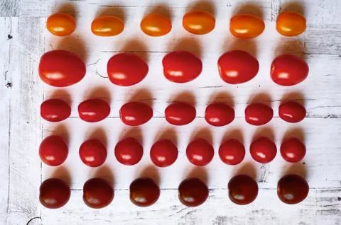 Five types of cherry tomatoes on a light wooden background from above close up Stock Photos