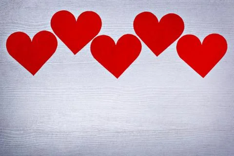 Five valentines hearts lined in a row on white wooden boards with place for text Foto stock