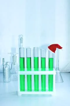 Five vials of green solution in a chemical lab. on the end tube is a miniature Photos