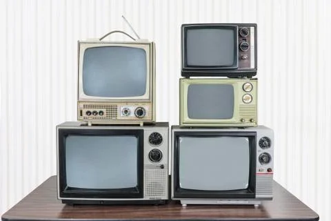 Five Vintage Televisions Stacked on Table Stock Photos