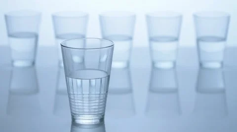 Five water glasses, one in front, four in the back - tilt Stock Footage 11606403