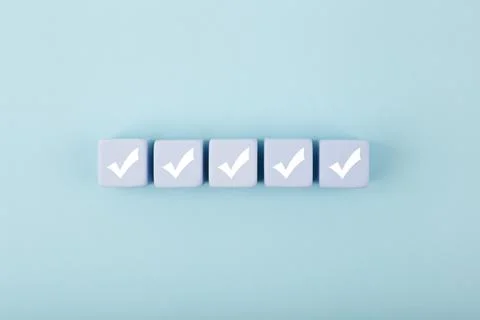 Five white checkmarks on white cubes against bright pastel blue background Stock Illustration
