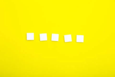 Five white empty squares for letters on a yellow background. Stock Photos