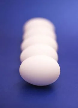 Five white raw eggs lie on the table. Vertical photo, large eggs. Preparing f Stock Photos