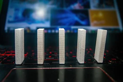 Five white rectangular blocks standing upright on a laptop keyboard with a .. Stock Photos