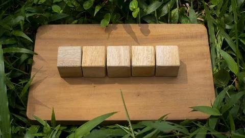 Five Wooden Blocks Aligned on Rustic Wooden Board Flat Lay Concept Stock Photos