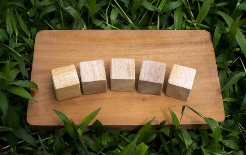 Five Wooden Cubes Aligned on Rustic Wooden Board Flat Lay Concept Stock Photos