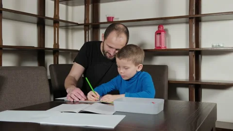 A five-year-old boy and his father do homework Stock Footage 168312616