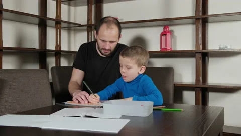 A five-year-old boy and his father do homework Видео 221777988
