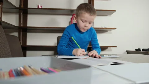 A five-year-old boy draws with a pencil Video stock 169601396