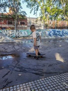 A five year old boy gets on a skateboard. Buenos Aires, Argentina. Stock Photos