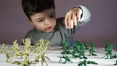 Five year old boy playing with toy soldiers Stock-Footage 82489514