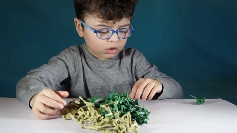 Five year old boy playing with toy soldiers Stock Footage 82489566