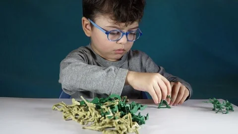 Five year old boy playing with toy soldiers Stock Footage 82489574
