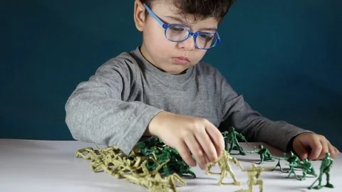 Five year old boy playing with toy soldiers Stock Footage 82489608
