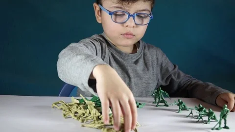 Five year old boy playing with toy soldiers Stock-Footage 82489610