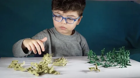 Five year old boy playing with toy soldiers Stock-Footage 82489669