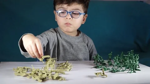 Five year old boy playing with toy soldiers Stock Footage 82489677