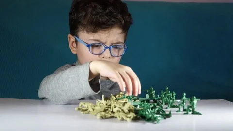 Five year old boy playing with toy soldiers Stock Footage 82489682