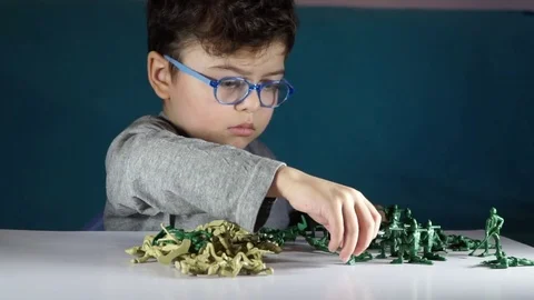 Five year old boy playing with toy soldiers Stock-Footage 82489694