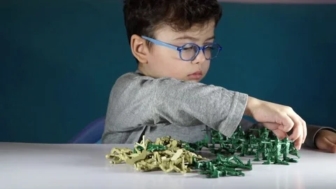 Five year old boy playing with toy soldiers Stock-Footage 82489743
