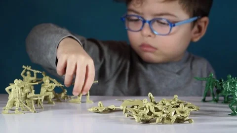 Five year old boy playing with toy soldiers Stock-Footage 82489780