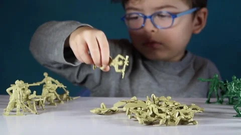 Five year old boy playing with toy soldiers Stock-Footage 82489787