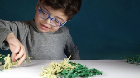 Five year old boy playing with toy soldiers Stock-Footage 82489881