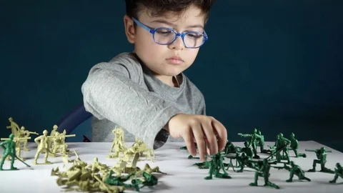 Five year old boy playing with toy soldiers Stock-Footage 82489905