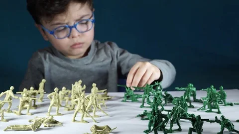 Five year old boy playing with toy soldiers Stock-Footage 82489972