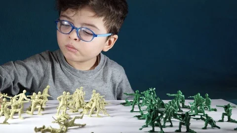 Five year old boy playing with toy soldiers Stock-Footage 82489975