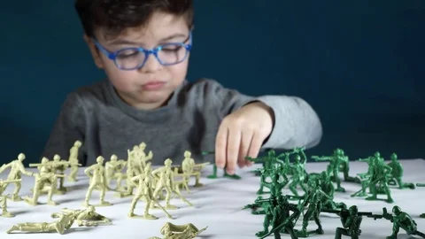 Five year old boy playing with toy soldiers Stock-Footage 82490007