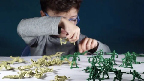 Five year old boy playing with toy soldiers Stock-Footage 82490039