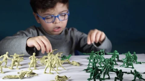 Five year old boy playing with toy soldiers Stock Footage 82490078