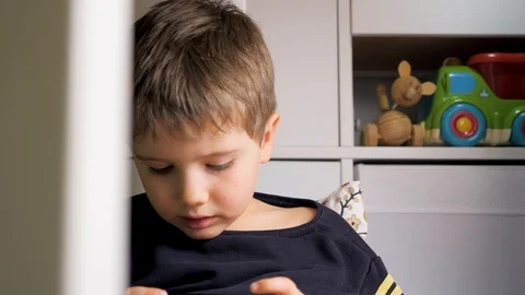 Five year old boy playing video game on mobile phone. Preschooler plays game on Stock Footage 123975383