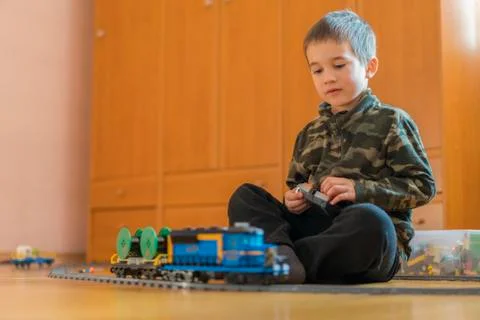 Five year old boy playing on the floor by rail. Little boy playing with railw Stock Photos