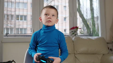 A five year old boy plays a console Stockbeeldmateriaal 168291552