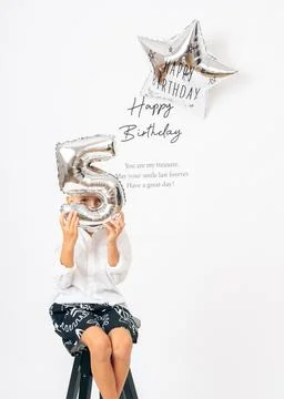 Five-year-old boy posing with number 5 balloon on birthday Foto stock