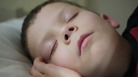 A five-year-old boy sleeps in his crib Видео 210594827
