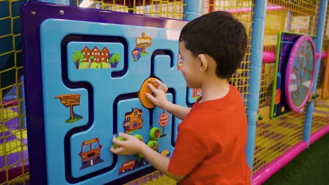 A five-year-old little boy playing a puzzle game at an amusement park Stock Footage 169395316
