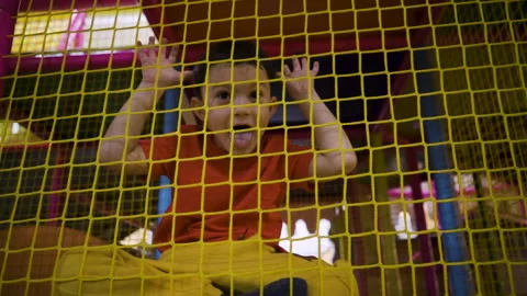 A five-year-old little boy wriggles in front of a camera in an amusement park Video stock 169395384
