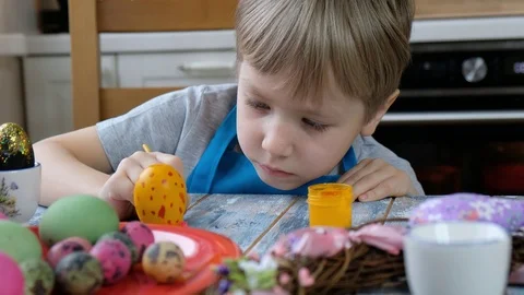 Five years old child boy kid coloring easter eggs in the kitchen. Stock-Footage 122802998