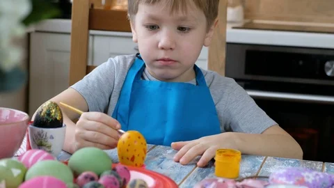Five years old child boy kid coloring easter eggs in the kitchen. Stock Footage 123041692
