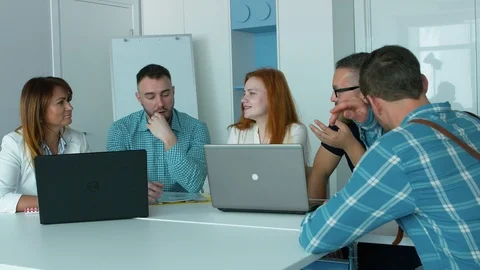 Five young employees in the office actively discuss work cases during the mee Stock Footage 93864923