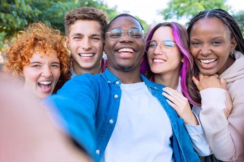 Five young multiracial friends taking a selfie portrait together outdoors Stock Photos