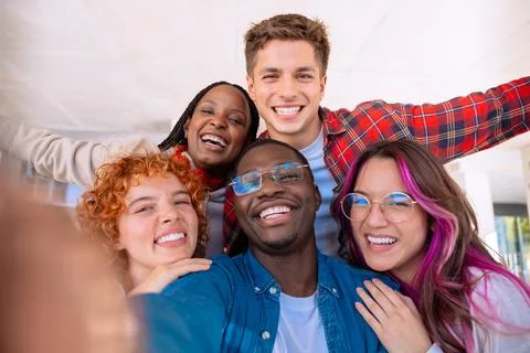 Five young multiracial friends taking a selfie portrait together outdoors Stock Photos
