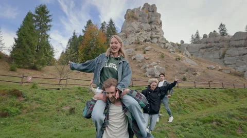 Five Young People Having Fun In Nature. Man With Beard Carries Girl On His Back Vidéo 167969268
