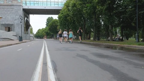 Five young people run along the city s embankment on a summer day and greet the Stock Footage 113060904