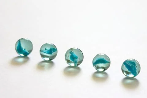 Five zero round glass marbles on white background Stock Photos